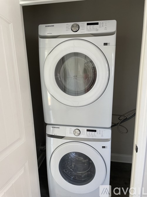 A white Samsung washing machine sits in a laundry room.