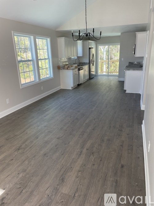 A spacious kitchen with white cabinets and a large island.