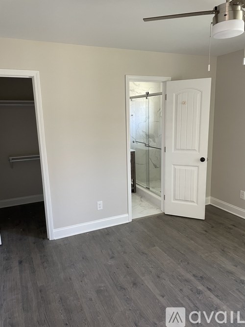 A room with a white door and a grey floor.