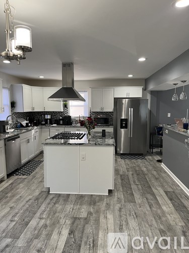A modern kitchen with a stove top oven and a refrigerator.