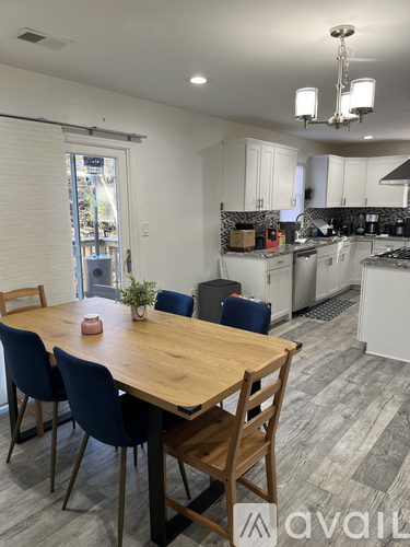 A dining room with a wooden table and chairs.