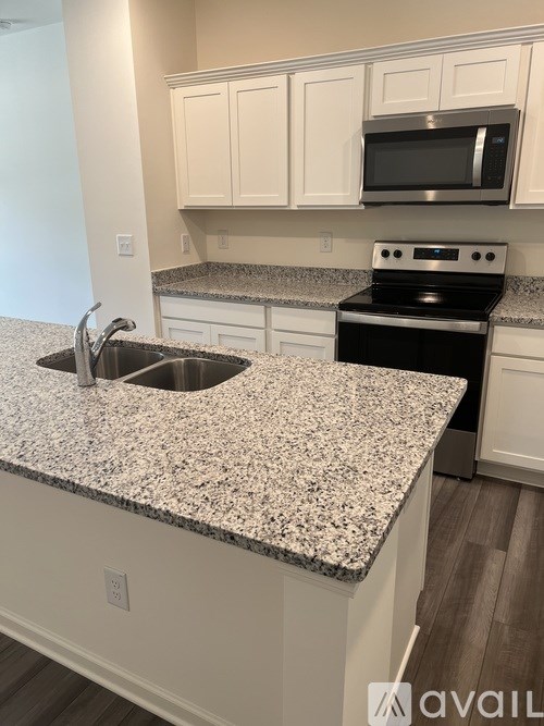 A kitchen with granite countertops and white cabinets.