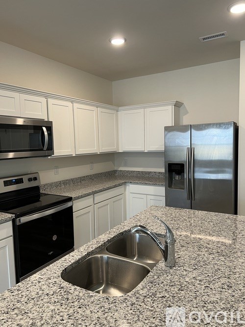 A kitchen with granite countertops and stainless steel appliances.