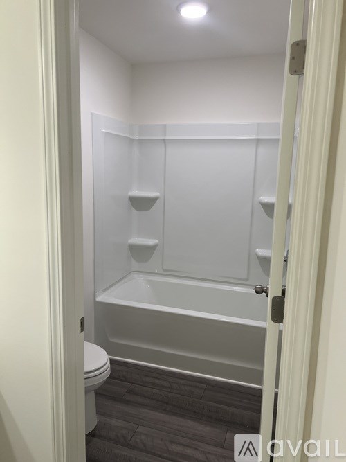 A white bathroom with a toilet and a bathtub.