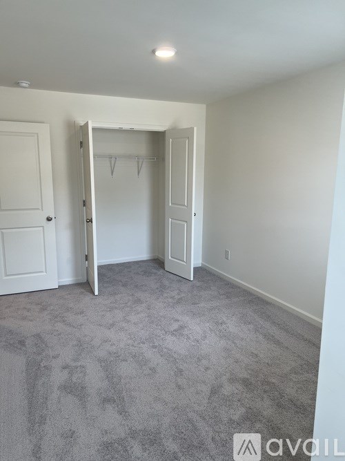 A room with a grey carpet and a white door.