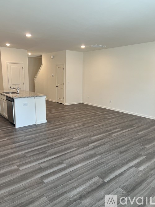 A kitchen with a white cabinet and a sink is visible.