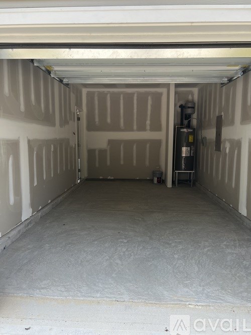 The image shows an empty garage with a closed door and a wall on the left side.