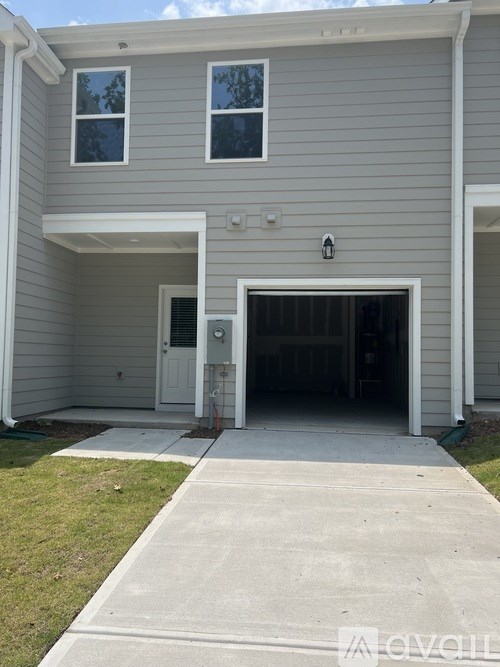 A grey house with a white door and windows.
