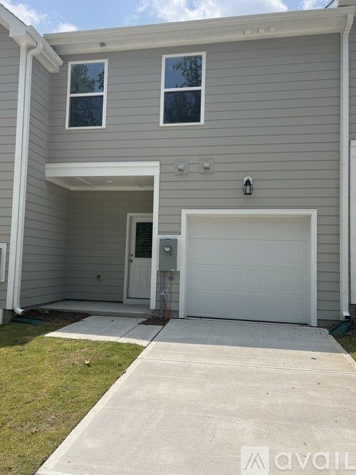 A two-story house with a garage door and a small window.