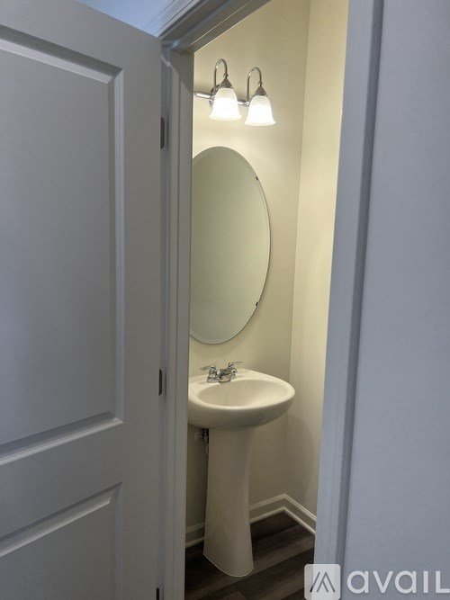 A white sink with a round mirror above it.