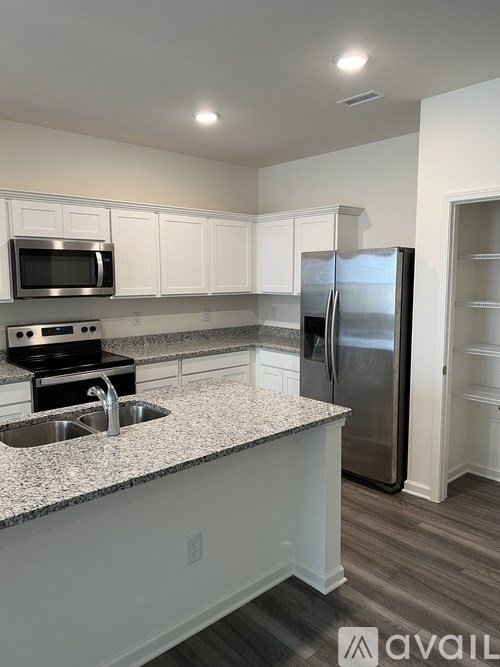 A kitchen with a granite countertop and stainless steel appliances.