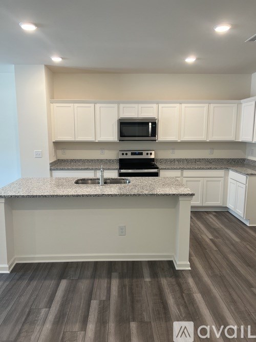 A kitchen with a granite countertop and white cabinets.