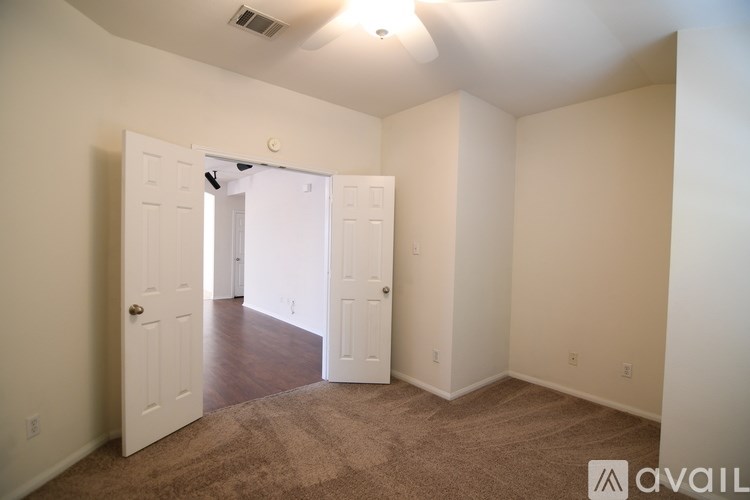 A room with a carpeted floor and a doorway leading to another room.
