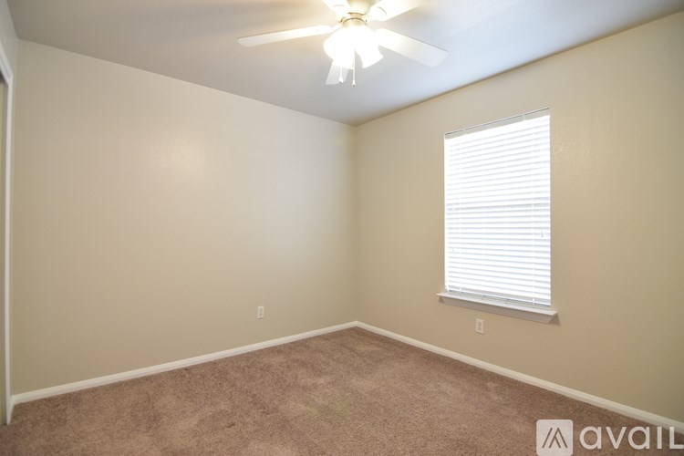 A room with wooden flooring and a ceiling fan.