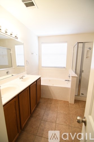A bathroom with a tub, sink, and mirror.