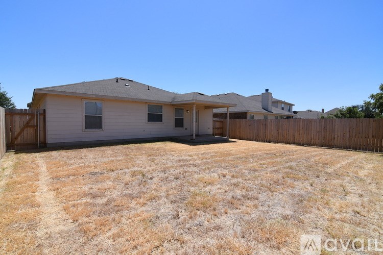 A house with a fence and a yard is available for rent.