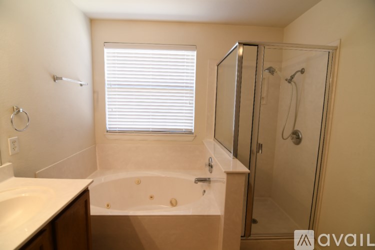 A house with a fence in the foreground and a clear blue sky.