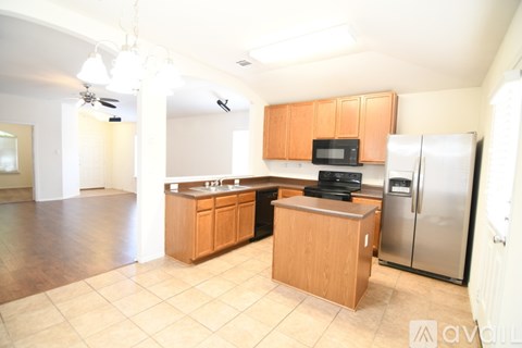 A kitchen with wooden cabinets and a refrigerator.