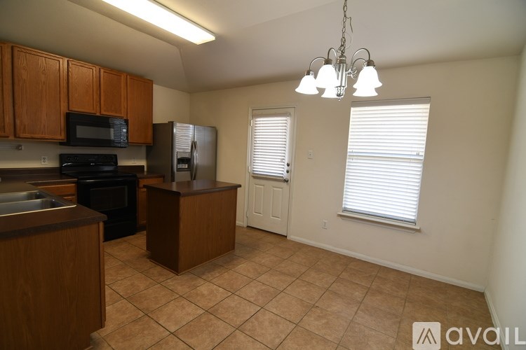 A kitchen with wooden cabinets and a microwave on top of the oven.