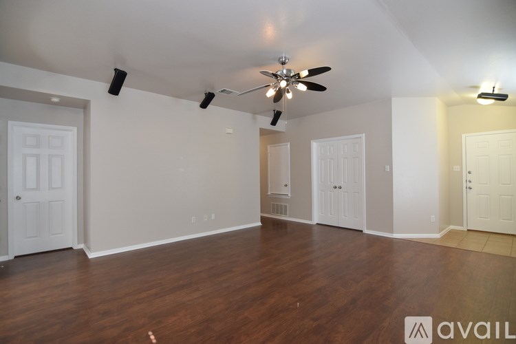 A room with wooden floors and a ceiling fan.