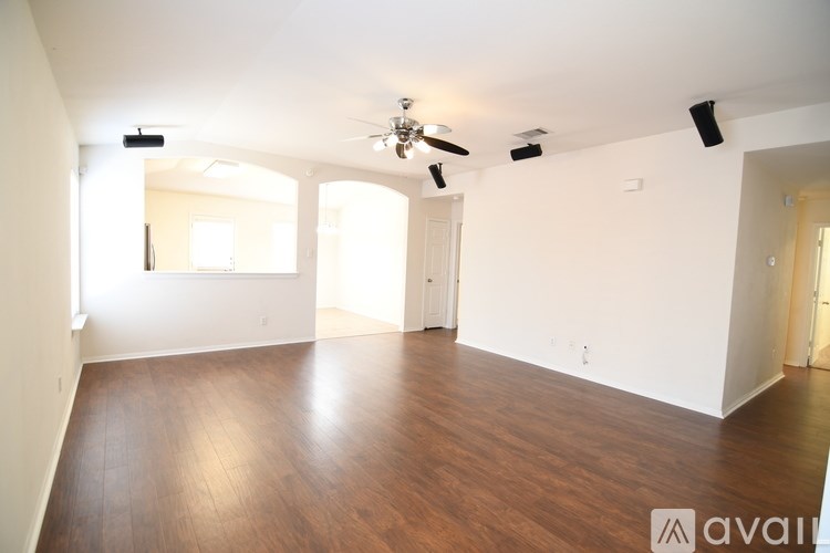 A spacious room with wooden floors and white walls.