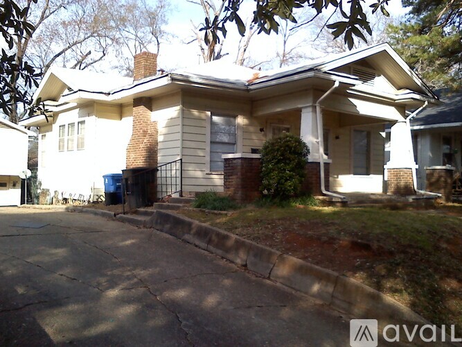 A house with a white exterior and a brown roof is shown.
