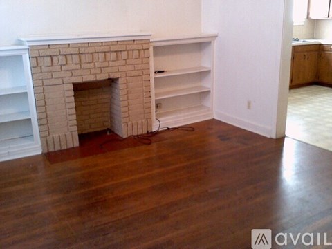 A room with a fireplace and wooden floors.