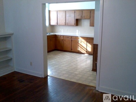 A kitchen with wooden cabinets and a tiled floor.