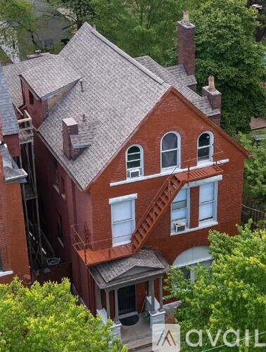 A red brick house with a staircase leading to the second floor.