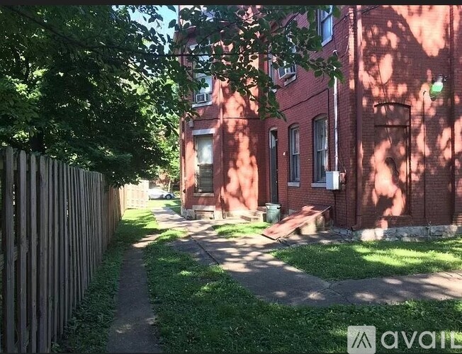 A red brick building with a green lawn in front.