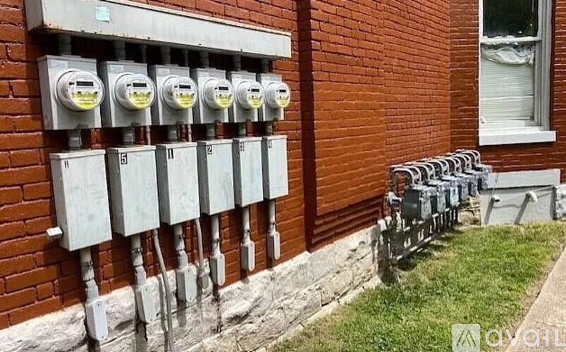 A row of parking meters are lined up on a sidewalk.