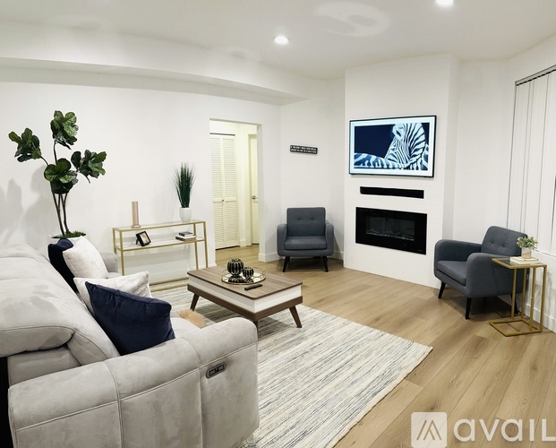 A living room with a grey couch, a coffee table, and a fireplace.