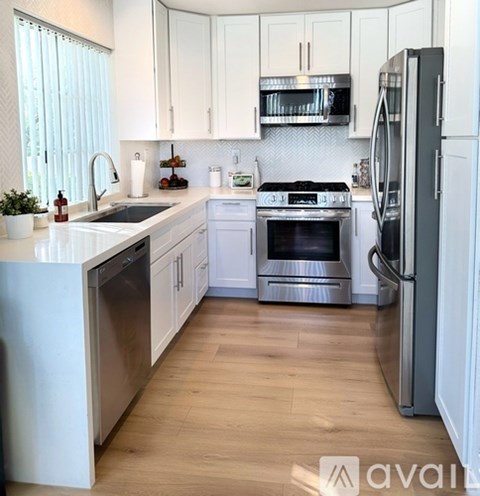 A kitchen with white cabinets and stainless steel appliances.