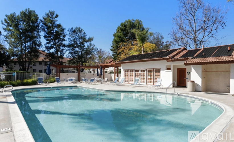A large swimming pool surrounded by trees and a building.