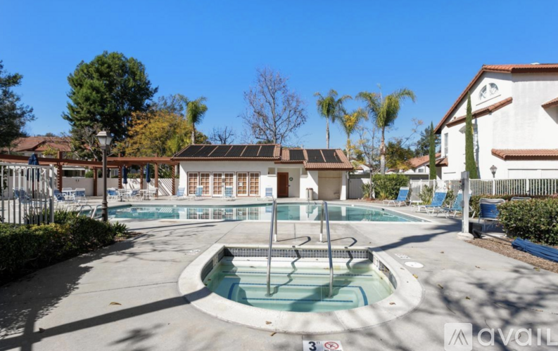 A pool area with a slide and a building in the background.