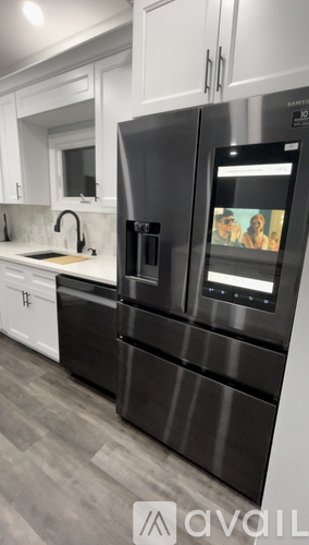 A modern kitchen with a black fridge and stainless steel appliances.
