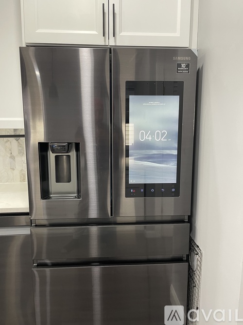 A stainless steel refrigerator with a digital display showing the time.