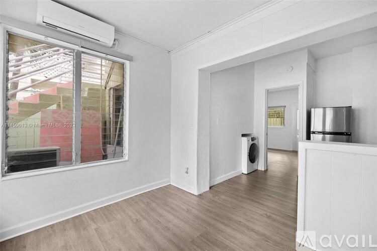 A room with a window, a door, and a wall-mounted air conditioner.