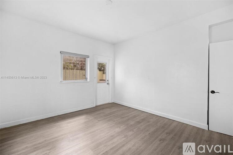 A room with a white door and a framed picture on the wall.