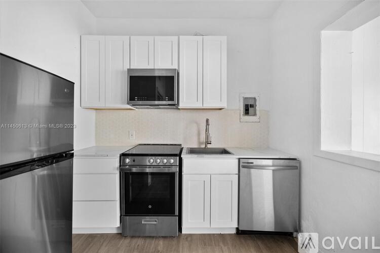 A kitchen with white cabinets and a black oven.