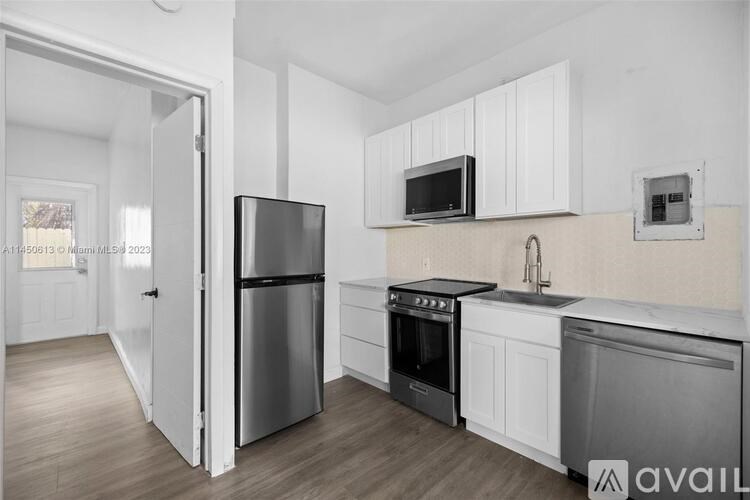A kitchen with white cabinets and stainless steel appliances.