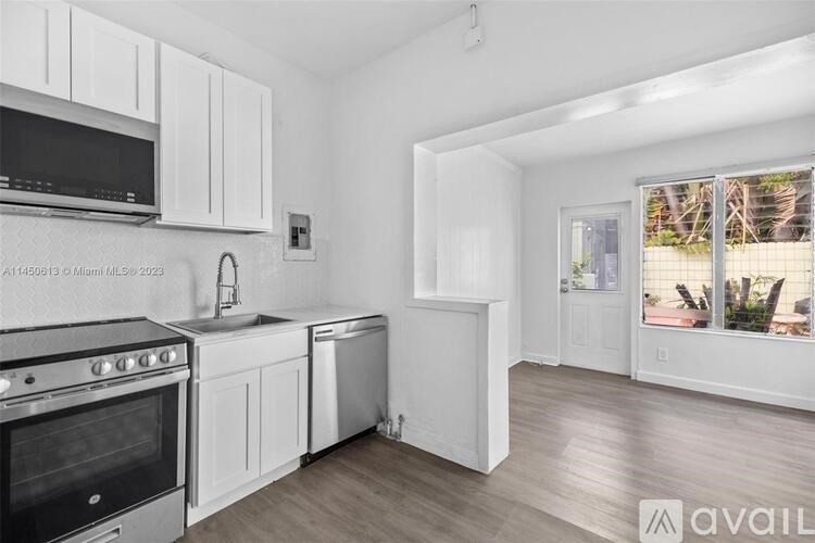 A kitchen with white cabinets and a black oven.