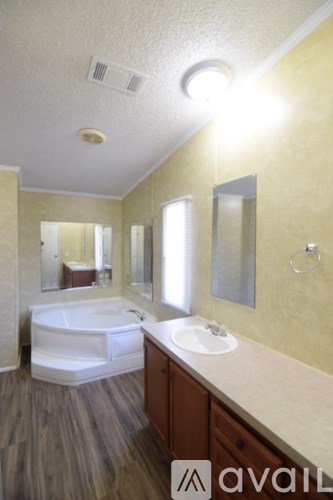 A bathroom with a tub, sink, and mirror.