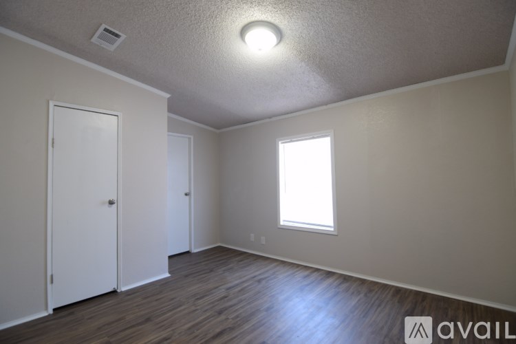 A room with a window and wooden flooring.