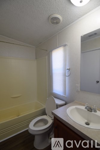A bathroom with a toilet, sink, and bathtub.