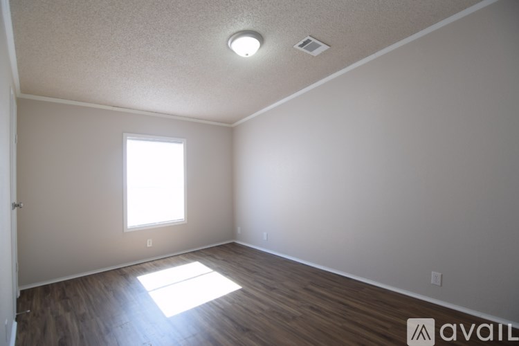 A room with a window and wooden flooring is available for rent.
