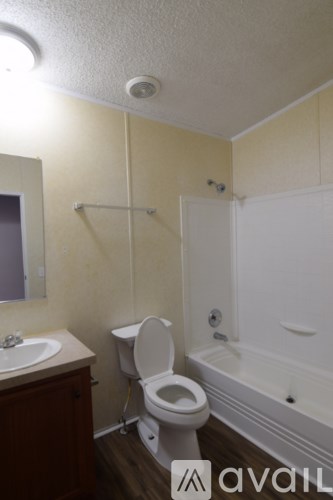A bathroom with a toilet, sink, and bathtub.