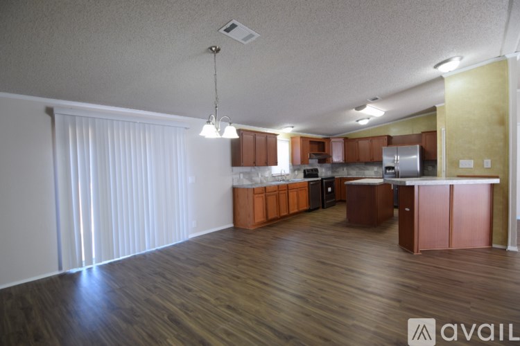 A kitchen with wooden floors and a white ceiling.
