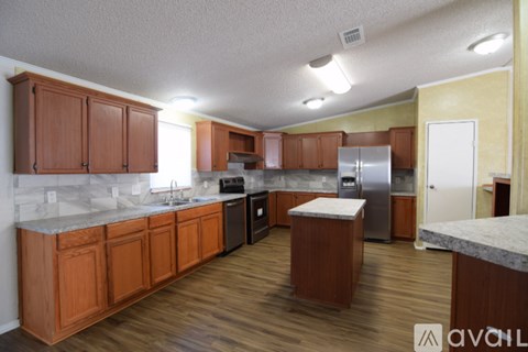A kitchen with wooden cabinets and a marble countertop.
