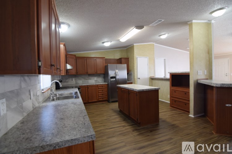 A kitchen with wooden cabinets and a marble countertop.